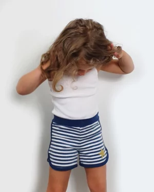 Short enfant en maille issu du patron short enfant PDF New Magik, présenté porté ou à plat, coupe simple pour grandes gambettes.